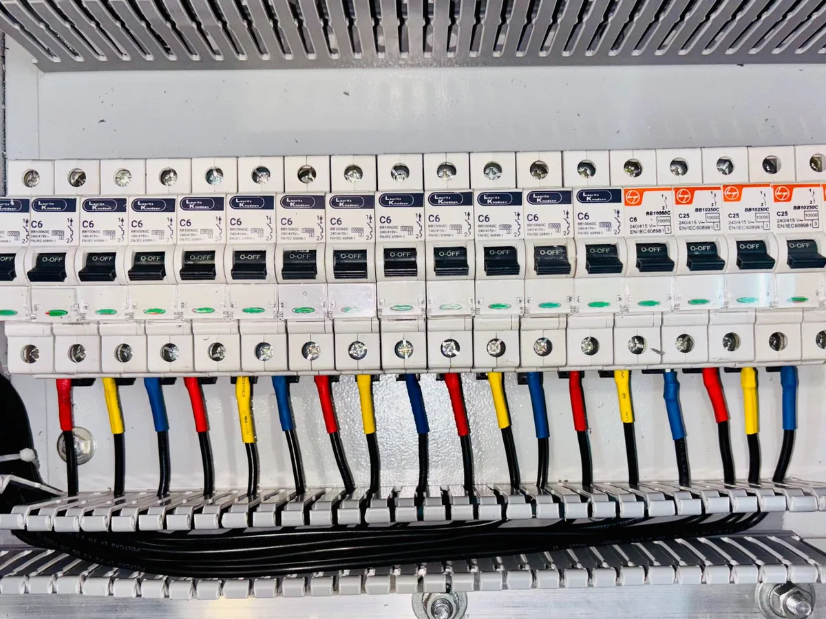 Großer Zähler- und Verteilerschrank mit mehreren Reihen Leitungsschutzschaltern und digitalen Zähleranzeigen.